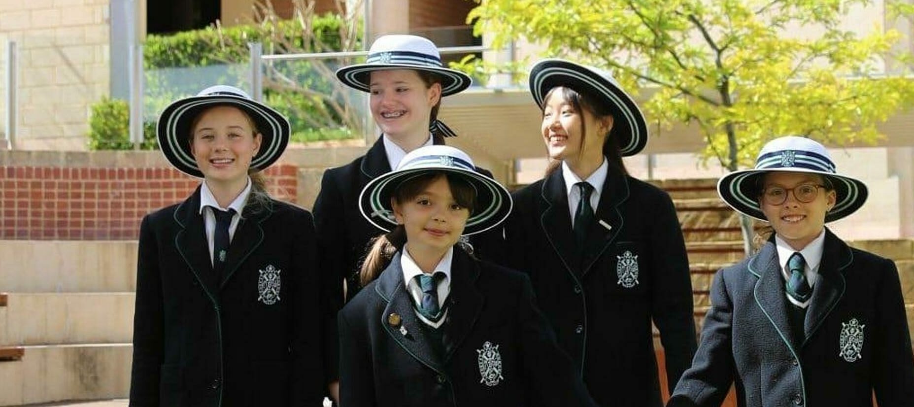 5 female students of various ages wearing Presbyterian Ladies College uniforms in a courtyard