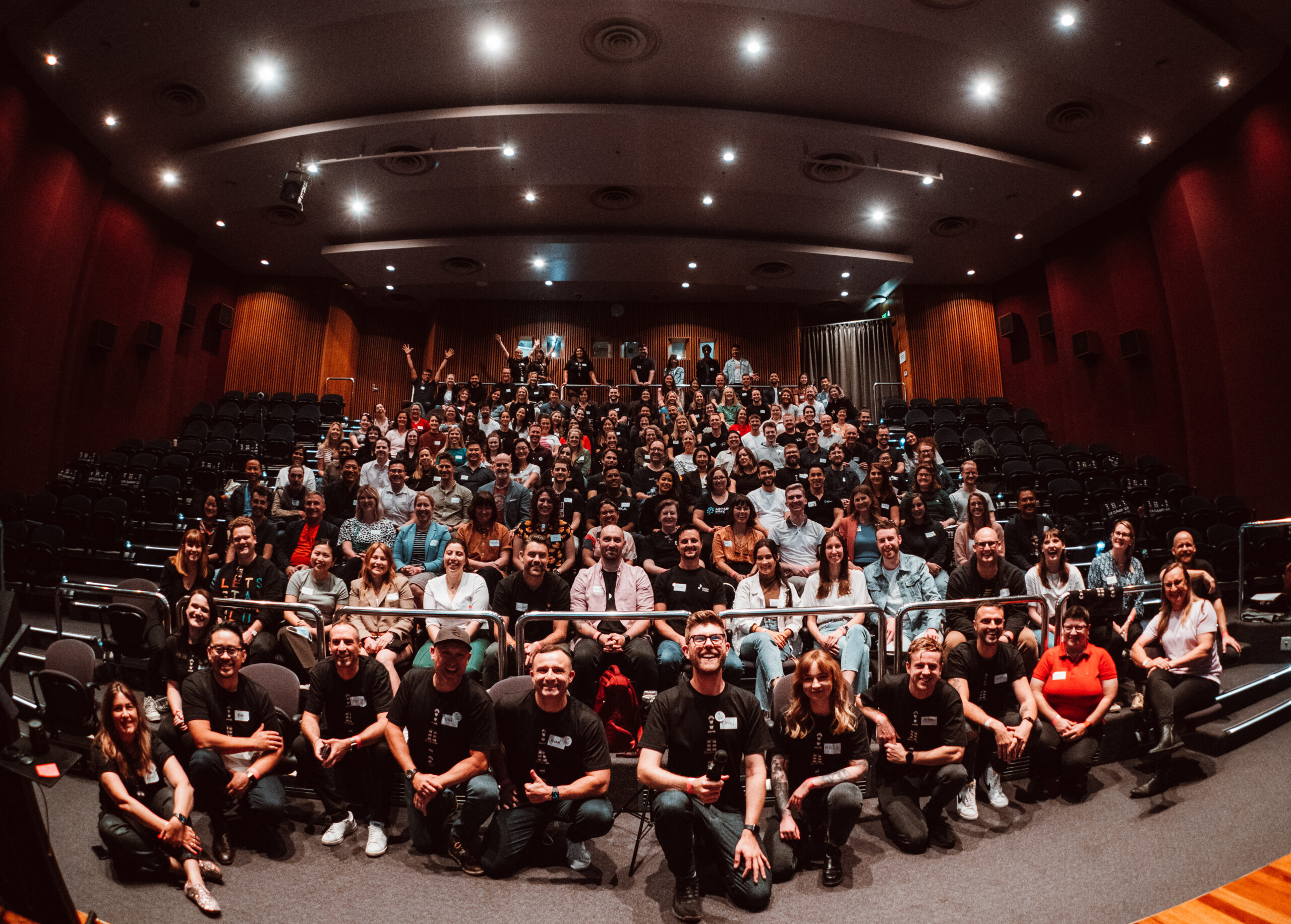 Large crowd of attendees of the UX Camp 2022 posing for a photo in auditorium